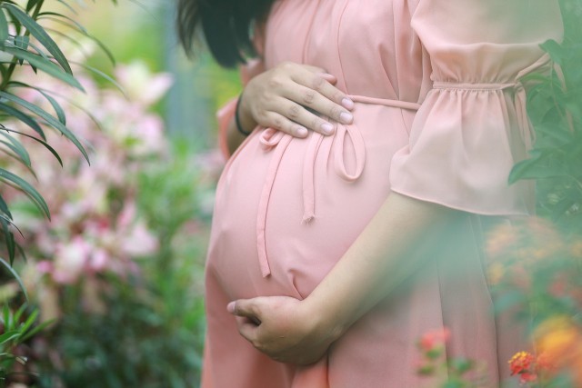 schwangere Frau mit Händen um den Bauch